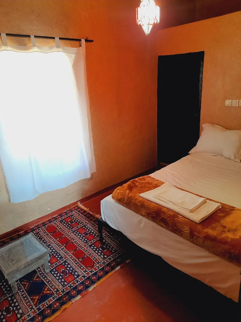 Double or Twin Room: the bed by a curtained window