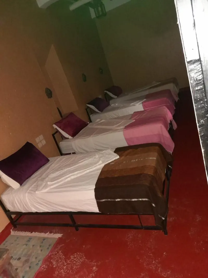 Quadruple Room: the four single beds and a blue rug