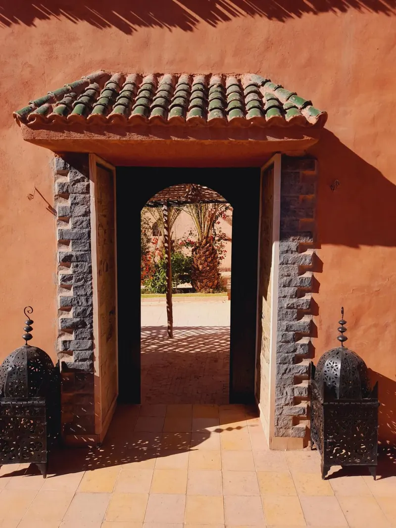 The gate under its small tiled roof, with a lantern on each side and an arched doorway beyond